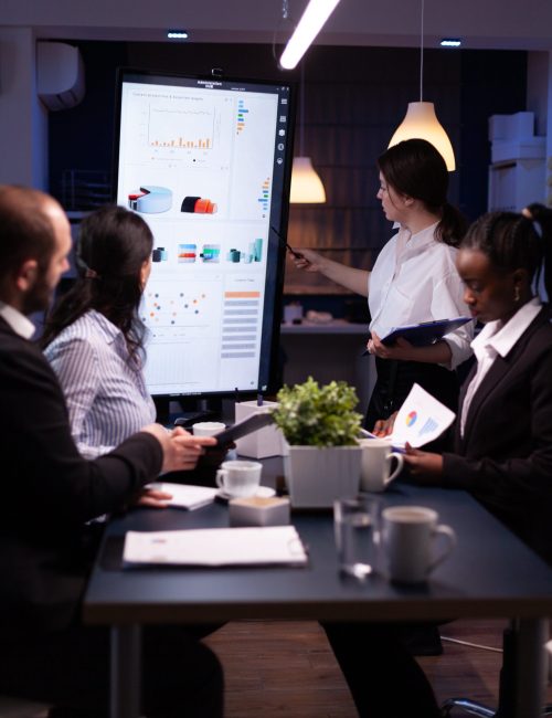diverse-multi-ethnic-business-teamwork-overworking-office-meeting-room-analyzing-financial-graphs-min